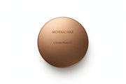 Mossicare Cream Bronzer — round metallic bronze compact, top-down product shot on a clean white background