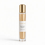 Mossicare Dewy Liquid Highlighter — clear cylindrical bottle with shiny gold cap, showing a shimmery texture swatch
