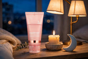 Mossicare Collagen Night Wrapping Mask – pink tube standing on a wooden table in a cozy nighttime bedroom setting with a lit candle, warm lamp, and moon-shaped decor beside it